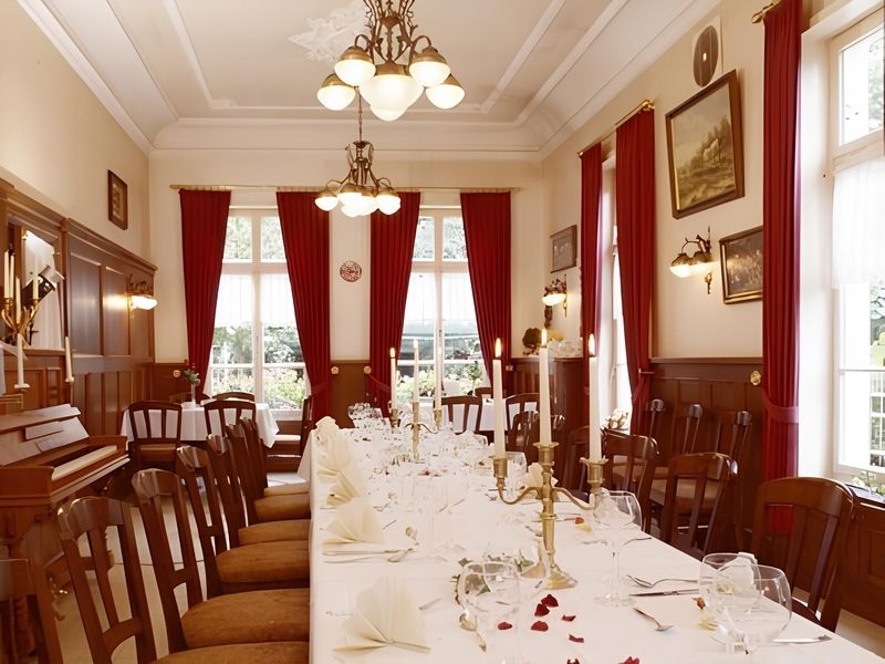 goede kamer met een gedekte tafel en rode gordijnen